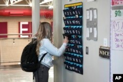 Učenica devetog razreda stavlja svoj telefon u držač dok ulazi u razred srednje škole Delta (Utah), 23. februara 2024. Mnoge škole pokušavaju regulisati upotrebu mobilnih telefona učenika, ali djeca ne poštuju uvijek pravila i škole ih provode sporadično.