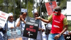 Demonstrators wear mock prison outfits to show