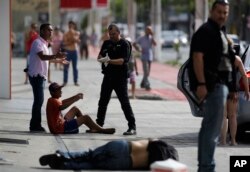 Civil police detain looters after they were shot in their legs, in Vitoria, Espirito Santo state, Brazil, Feb. 6, 2017.