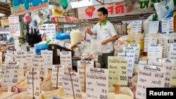 FILE - A Thai vendor weighs a bag of rice at a market in central Bangkok.