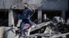 Palestinac beži iz ruševina zgrade u Pojasu Gaze, 21. februar 2024. (AP/Adel Hana)
