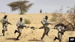 Dans cette photo du 18 mars 2004, des soldats maliens s'entrainent aux côtés des forces spéciales américaines près de Tombouctou, dans le cadre de l'Initiative pan-sahélienne américaine.