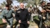 FILE - Iraq's Prime Minister Haider al-Abadi (in black) walks during a visit to an Iraqi army base in Camp Tariq near Fallujah, Iraq, June 1, 2016. Abadi is calling on residents of Mosul to cooperate with government forces that will be participating in operations to retake the city from IS militants.