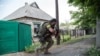Tentara pemerintah Ukraina mengusung senjata di Marinka, Donetsk.