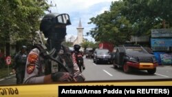 Polisi wakilinda doria nje ya Kanisa Katoliki, huku njia zikiwa zimefungwa baada mlipuko wa mabomu,kwenye mji mkuu Makassar, katika jimbo la Sulawesi, Indonesia, Machi 28, 2021. Picha na Antara Foto. Antara Foto/Arnas Padda/ via REUTERS.