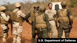 Un conseiller en contre-terrorisme parle à des soldats nigériens au Burkina Faso, le 21 février 2019.