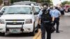 FILE - Police wear gas masks as they attempt to disperse a crowd that gathered after a shooting incident in St. Louis, Missouri August 19, 2015. 