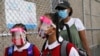 Students wear protective masks as they arrive for classes at the Immaculate Conception School while observing COVID-19 prevention protocols, Sept. 9, 2020, in The Bronx borough of New York.