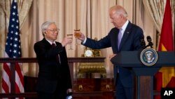 资料照片：2015年7月7日，时任美国副总统拜登在国务院午宴上和越南共产党总书记阮富仲祝酒。（美联社照片）