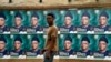 FILE - A man walks past campaign posters displayed in Osogbo, Osun State in southwest Nigeria, July 15, 2022. Fact-checkers across the country say they are joining forces to counter misinformation in the runup to the general election.