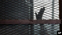 Un accusé en cage dans une salle d'audience de la prison de la Torah, dans le sud du Caire, en Égypte, le 22 août 2015.
