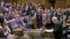 Britain's Prime Minister Boris Johnson delivers a statement to lawmakers inside a crowded House of Commons in London, Oct. 19, 2019. At a rare weekend session, Johnson implored legislators to ratify a last-minute Brexit deal he struck with EU leaders.