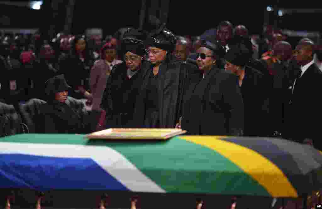 Winnie Madikizela-Mandela, mantan istri Nelson Mandela, kiri dan janda Nelson Mandela Graca Machel berdiri di dekat peti mati mantan presiden Afrika Selatan tersebut pada upacara pemakamannya di Qunu.