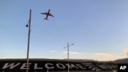 FILE - A sign painted near the runway of the Wellington International Airport greets travelers returning home in Wellington, New Zealand, April 19, 2021. The sign reads "Welcome Whanau" with the second word an Indigenous Maori word meaning family. (AP Photo/Nick Perry)