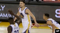 Klay Thompson, au centre, avec ses coéquipiers Draymond Green et Stephen Curry des Golden State Warriors, Oakland, Californie, le 2 juin 2016