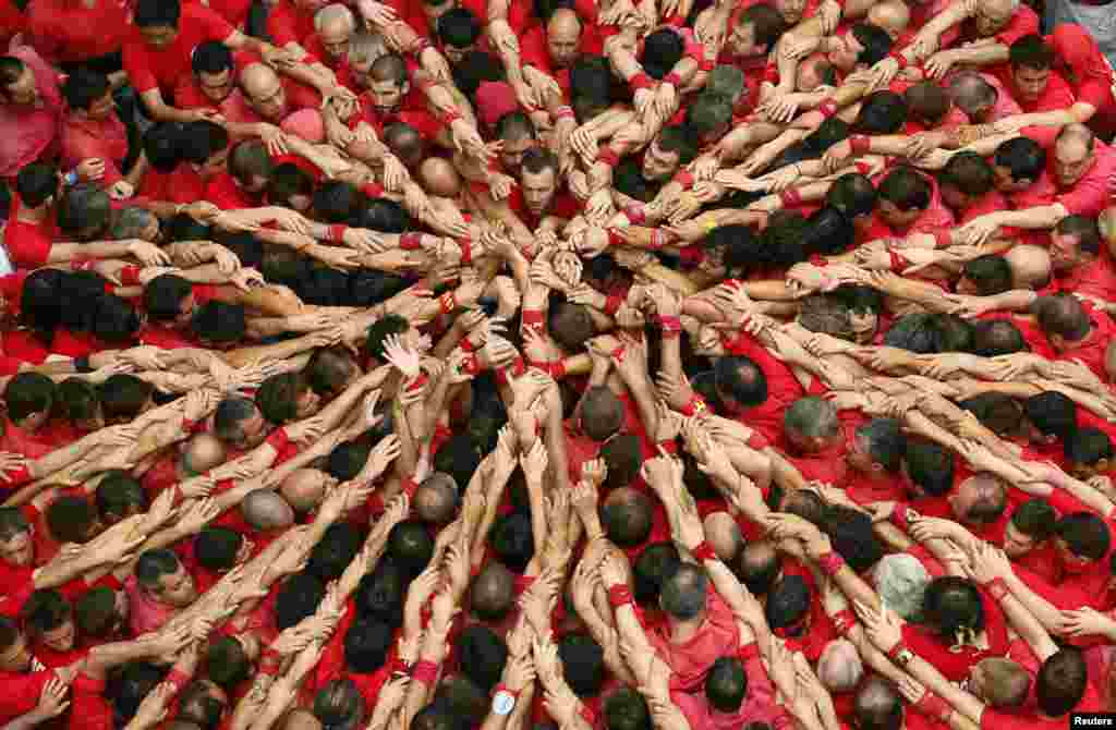 Warga di kota Barcelona merayakan festival &#39;Sant Joan&#39; (Yohanes) di Plaza del Blat dengan membentuk &#39;menara manusia&#39;.