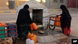 Des Marocaines remplissant des conteneurs, à Zagora, au Maroc, le 19 octobre 2017. 