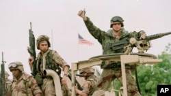 Un soldat de la Marine américaine lève son doigt à bord d’une camionnette à la réouverture de l’ambassade des Etats-Unis à Mogadiscio, Somalie, 10 décembre 1992
