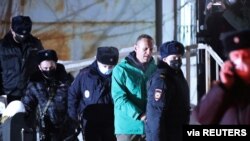 俄罗斯反对派领袖纳瓦尔尼在莫斯科城外的希姆基的一次法庭听证之后被警察押送走。(2021年1月18日)