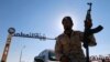 FILE - A member of Libyan forces loyal to eastern commander Khalifa Haftar holds a weapon as he sits on a car in front of the gate at Zueitina oil terminal in Zueitina, west of Benghazi, Libya, Sept. 14, 2016. 