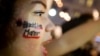 FILE - A woman with 'Black Lives Matter' written on her cheek demonstrates in Atlanta, Ga., against the deaths of unarmed black men at the hands of white police officers.