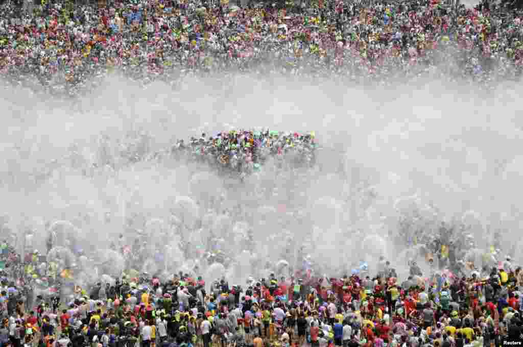 Para pengunjung berpartisipasi dalam percikan air tahunan untuk menandai Tahun Baru minoritas Dai ​​di Xishuang Banna, provinsi Yunnan, China, 15 April 2013.