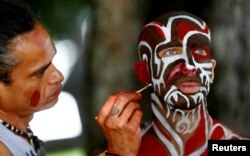 An artist touches up makeup on a model during the "World Bodypainting Festival 2017" in Klagenfurt, Austria, July 28, 2017.