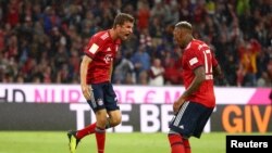 Thomas Mueller, à gauche, jubile après son premier but avec Jerome Boateng, lors d’un match de la bundesliga, 24 août 2018 