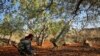 FILE - A Syrian rebel fighter prepares to fire a rocket toward a position held by regime forces, in the southern countryside of Syria's rebel-held Idlib province, Nov. 13, 2020.