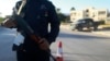 A security officer stands with his weapon on a road leading to a police station in Benghazi, Dec. 4, 2014. 