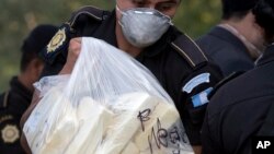 FILE - A drug police agent carries a bag of cocaine packages to be incinerated in Guatemala City, April 23, 2008. 