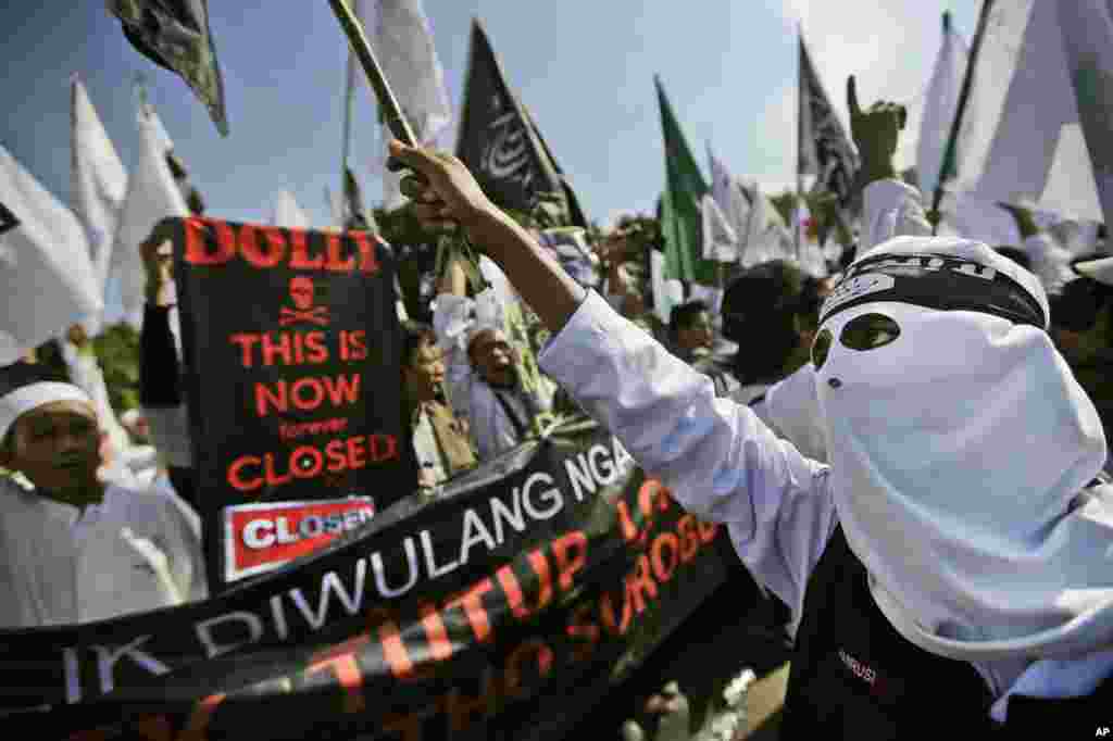 Demonstran memprotes langkah pemerintah kota Surabaya dalam menutup kompleks lokalisasi Dolly (18/6). (AP/Dita Alangkara)