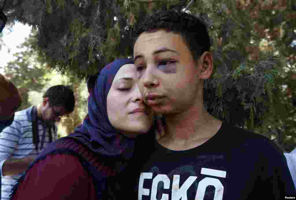 Tariq Khdeir (kanan) disambut ibunya setelah dibebaskan dari penjara di Yerusalem (6/7) dan dikenai tahanan rumah. Remaja Amerika keturunan Palestina itu dipukuli oleh polisi Israel di Yerusalem timur. Ia adalah sepupu Mohammed Abu Khudeir. (Reuters/Ronen Zvulun)