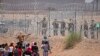 Migrants seeking to enter the United States through a barbed wire fence installed along the Rio Grande are driven away with pepper spray shots by Texas National Guard agents at the border with Ciudad Juarez, Chihuahua State, Mexico, on May 13, 2024. (Phot