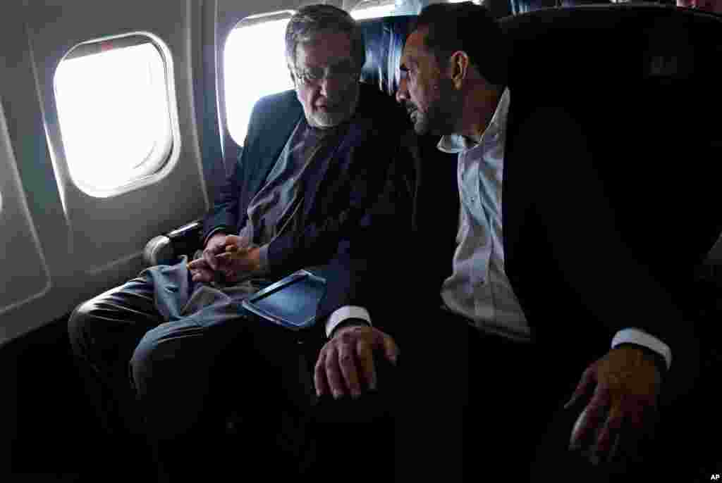 Kandidat presiden dan mantan menteri luar negeri Zalmai Rassoul (kiri) dan kandidat waktil presiden pertamanya, Ahmad Zia Massoud (kanan) berbicara dalam sebuah pesawat menuju Kabul (30/3). (AP/Massoud Hossaini)
