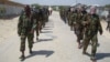 FILE - Members of Somalia's al-Shabab militant group patrol on foot on the outskirts of Mogadishu, Somalia, March 5, 2012. 