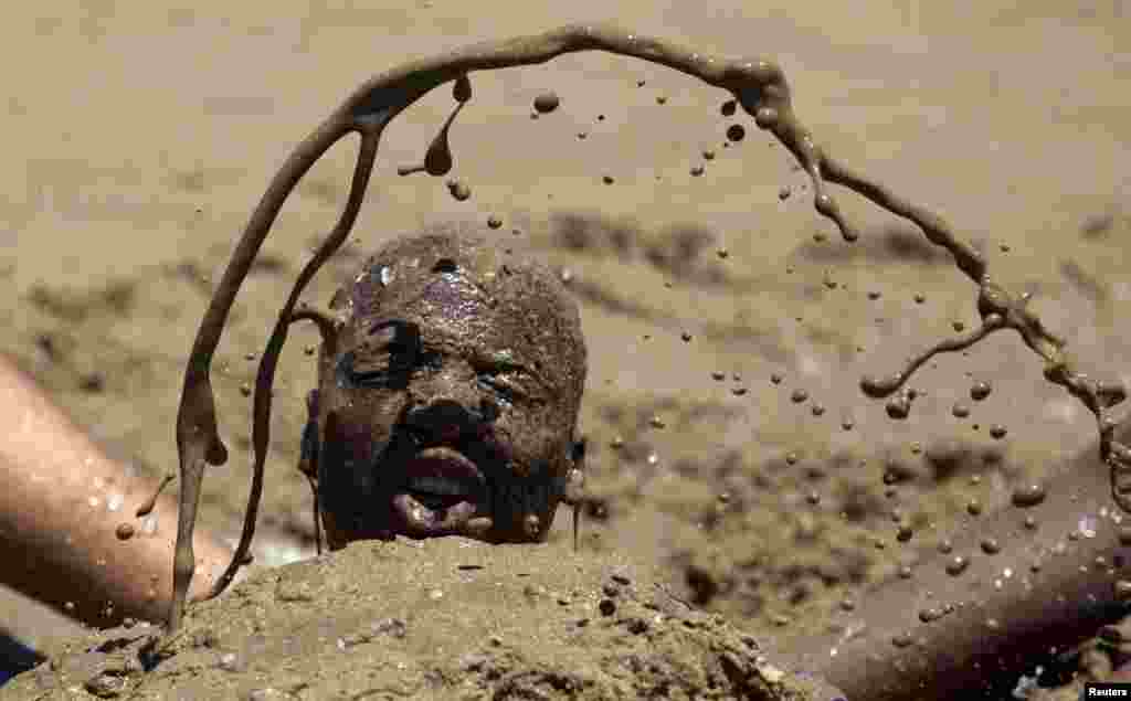 Seorang pria bermandikan pasir ketika warga Afrika Selatan merayakan hari pertama tahun baru di pantai Durban,&nbsp; Afrika Selatan. 