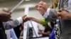 Corporate recruiters (R) gesture and shake hands as they talk with job seekers at a Hire Our Heroes job fair targeting unemployed military veterans and sponsored by the Cable Show, a cable television industry trade show in, Washington, June 11, 2013.