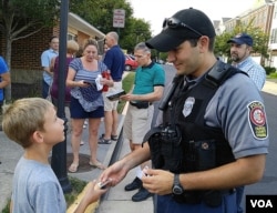 A boy gets a "junior" police badge during National Night Out in Fairfax Country, Virginia, Aug. 2, 2016. (D. Block/VOA)