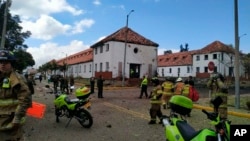 In this image provided by military personnel, emergency personnel respond to the scene of a deadly car bombing at a police academy, Jan. 17, 2019, in Bogota, Colombia.