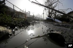 FILE - Downed power lines and debris are seen in the aftermath of Hurricane Maria in Yabucoa, Puerto Rico, Sept. 26, 2017.