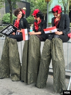 Women on stilts cheer for Egyptian President Abdel Fattah el-Sissi (VOA photo - C. Presutti).