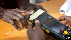 Un agent électoral lisant les empreintes digitales d'un électeur