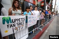 FILE - Fans wait at the premiere of "Muppets Most Wanted" at El Capitan theatre in Hollywood, Calif., March 11, 2014.