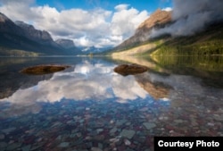 Sky and mountains reflecting on St. Mary’s Lake in Glacier National Park, Montana. (Photo by David Fortney, Courtesy of MacGillivray Freeman Films)