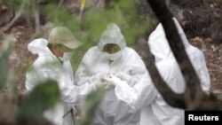 Teknisi forensik memeriksa sisa tulang yang terbakar yang ditemukan di lokasi yang dipercaya sebagai kuburan massal di sebuah lahan peternakan yang telah ditinggalkan di kota Garcia, pinggiran kota Monterrey, Meksiko, 31 Mei 2017 (foto: REUTERS/Daniel Becerril)