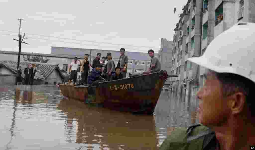 A rescue boat sails through a flooded street in Anju City, South Phyongan Province, North Korea, July 30, 2012.