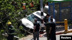 Israeli security forces and emergency personnel inspect the scene of a Palestinian car ramming attack near the Jewish settlement of Ofra near the West Bank city of Ramallah April 6, 2017.
