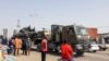 Des passants regardent un char transporté par camion dans les rues de N'Djamena, Tchad, le 3 janvier 2020
