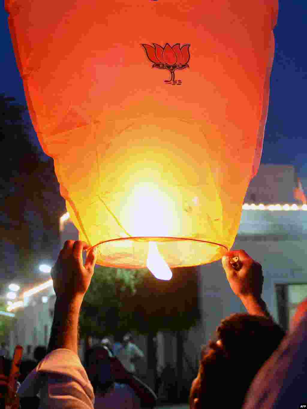 Seorang India pendukung Partai Bharatiya Janata (BJP) mempersiapkan peluncuran sebuah lentera udara yang dihiasi dengan lotus, simbol Partai BJP, di markas partai itu di New Delhi. &nbsp;